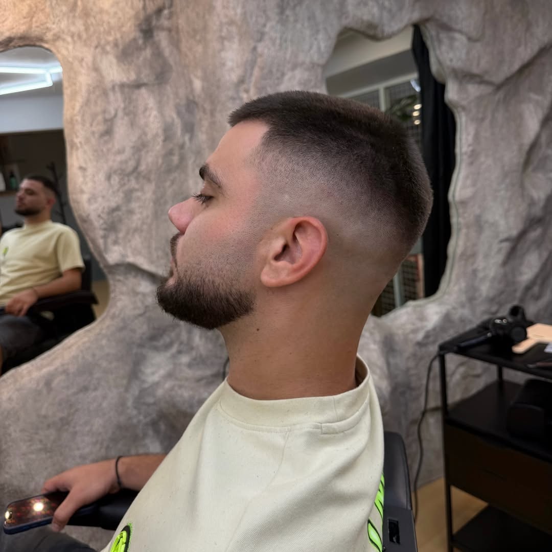 Skin fade με γενειάδα στο HIDEOUT, μπροστά στον πέτρινο τοίχο